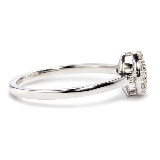 Close-up side angle of a white metal ring with a cluster of round white gemstones in prong settings on the top.