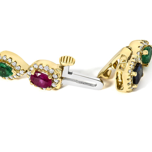 Close-up angle of a yellow metal bracelet clasp featuring oval-shaped red gemstones surrounded by small white gemstones, pear-shaped green gemstones, and other small round colored gemstones in prong settings.