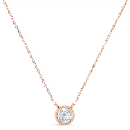 Close-up front view of a rose metal necklace with a single round white gemstone in a bezel setting pendant.
