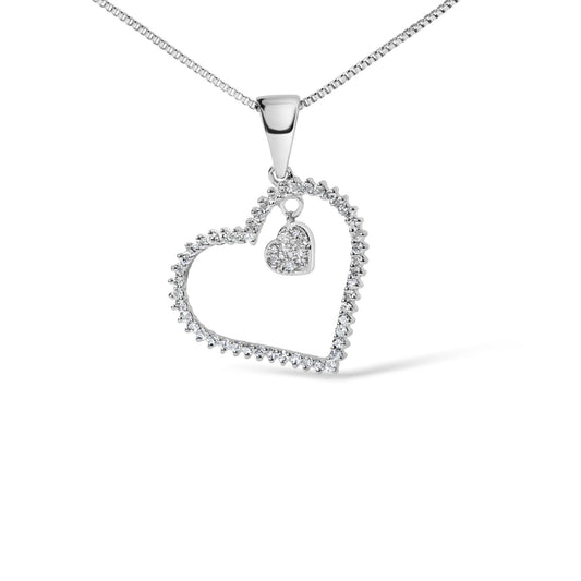 Close-up front view of a white necklace pendant featuring an open heart outline with round white gemstones in a prong setting, and a smaller solid heart charm encrusted with round white gemstones hanging inside the larger heart.