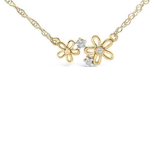 Close-up front view of a yellow metal necklace with two flower-shaped pendants; one flower has a white gemstone in the center, the other flower is plain, and two additional white gemstones are set near the flowers.