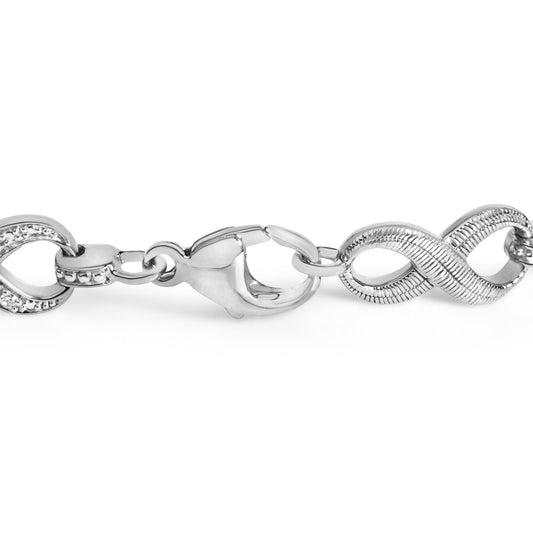 Close-up front angle of a white metal bracelet chain with some links featuring small round white gemstones in a pave setting.