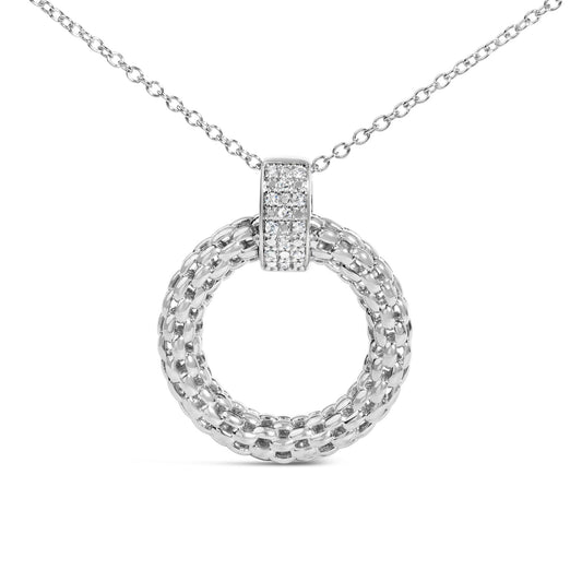 Close-up front view of a white metal necklace featuring a round pendant with a woven chain design and a micro-pave setting of small white gemstones on the pendant bail.
