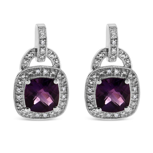 Front-facing close-up of a pair of white metal earrings featuring cushion-shaped purple gemstones in prong settings, surrounded by round white gemstones in pavé settings.
