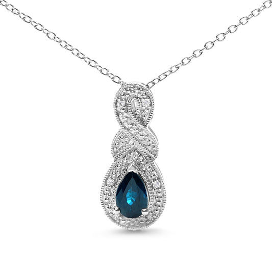 Front-facing close-up of a white metal necklace with an infinity-shaped pendant featuring a pear-shaped blue gemstone surrounded by small round white gemstones in prong settings.