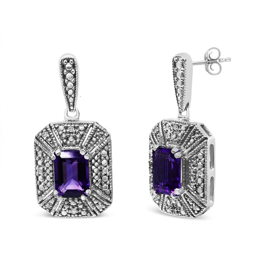 Pair of white metal earrings with purple emerald-shaped gemstones in center and surrounding round white gemstones, one earring shown from front and the other at a slight side angle.