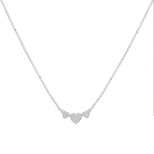 Front-facing shot of a white metal necklace with three heart-shaped pendants, each pavé set with white gemstones in an invisible setting.