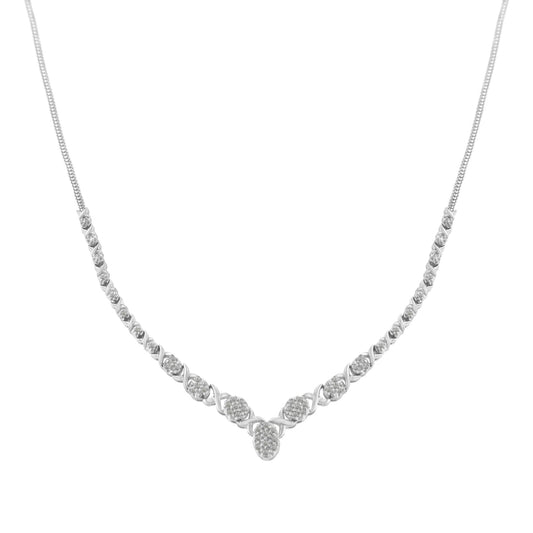 Front-facing shot of a white metal necklace with round white gemstones in prong settings arranged symmetrically along the chain, forming a gentle V shape at the center.
