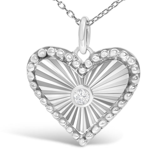 Close-up front view of a white heart-shaped necklace pendant with radiating textured lines, surrounded by rounded bead-like details, featuring a single round white gemstone in a bezel setting at the center, shown on a white background.