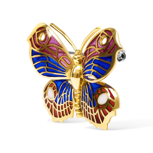 Yellow metal butterfly-shaped brooch with blue, red, and white enamel detailing, shown from a front angle.