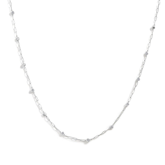 Close-up front angle of a white metal necklace with round white gemstones in bezel settings spaced along a delicate chain.
