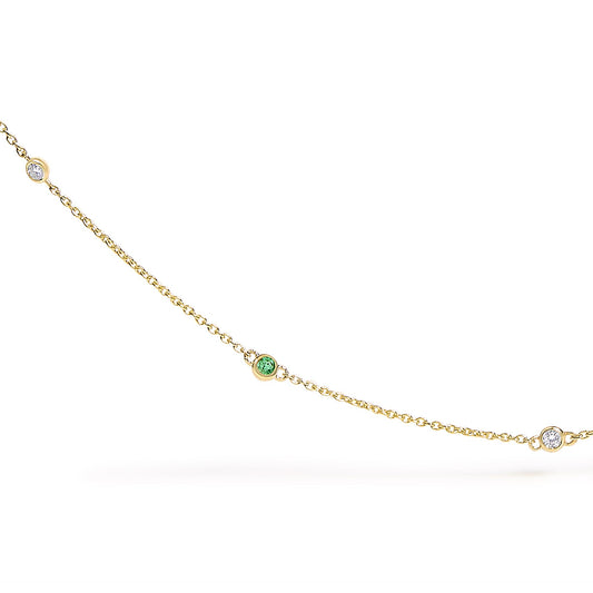 Close-up front view of a yellow metal necklace chain with round bezel-set white and green gemstones spaced along the chain.