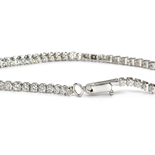 Close-up front angle of a white metal tennis bracelet featuring round white gemstones in prong settings, with the clasp and loop visible.