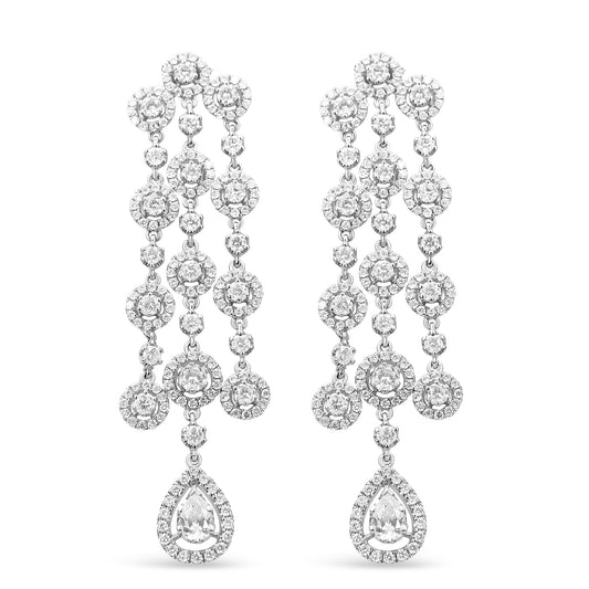 Front view of a pair of white metal chandelier earrings featuring multiple round white gemstones in prong and pave settings and a pear-shaped white gemstone at the bottom.