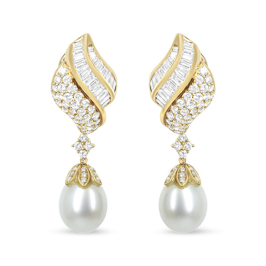 Front view of yellow metal drop earrings with curved design featuring channel-set white baguette-shaped gemstones, pavé-set round white gemstones, and large white pearl drops.