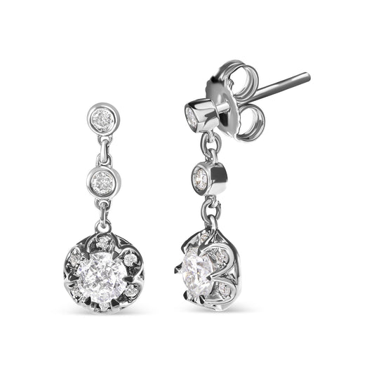 Front and side view of white metal dangling earrings with round white gemstones in prong and bezel settings.