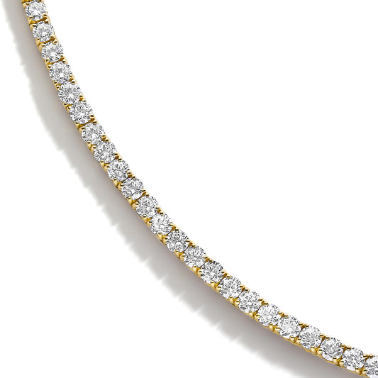 Close-up angle of a yellow necklace featuring a curved row of round white gemstones in a four-prong setting.