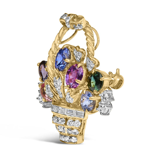 Yellow metal brooch with blue and purple oval and pear-shaped gemstones surrounded by white round and baguette gemstones in prong and channel settings, shown at a slight side angle.