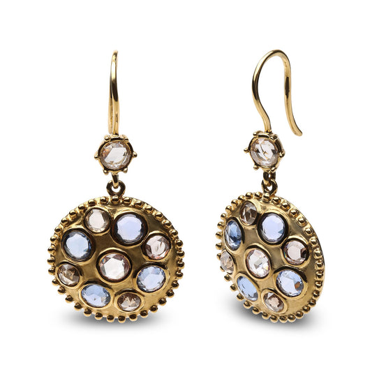 Pair of yellow metal earrings with round blue and brown gemstones and white gemstones in bezel settings, shown from a front and angled side view.