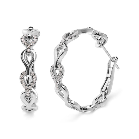 Close-up of white metal hoop earrings with interlocking loop design, featuring small round white gemstones in prong settings, shown from front and side angles.