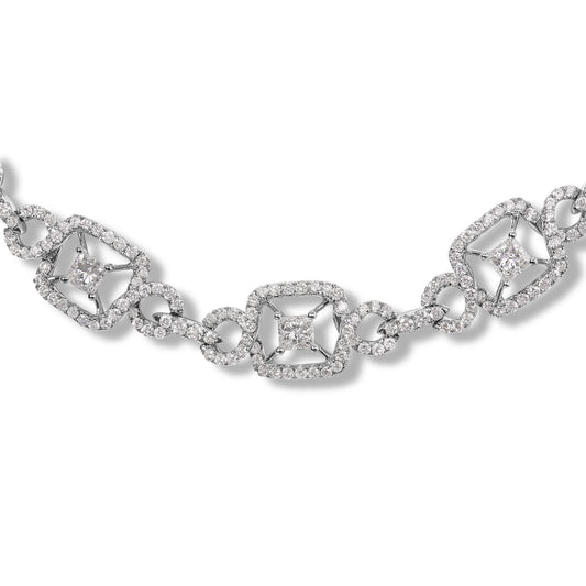 Close-up front angle of a white metal necklace featuring alternating princess-shaped and round-shaped white gemstones in prong settings, connected by round gemstone-encrusted links.