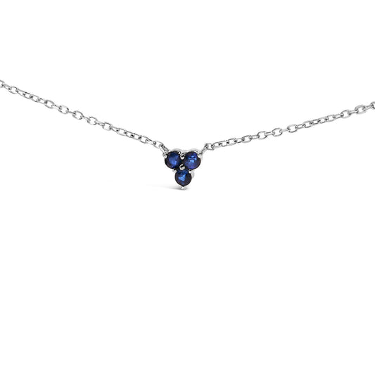 White metal necklace with a small pendant featuring three round blue gemstones in a triangular arrangement, shown from the front on a white background.