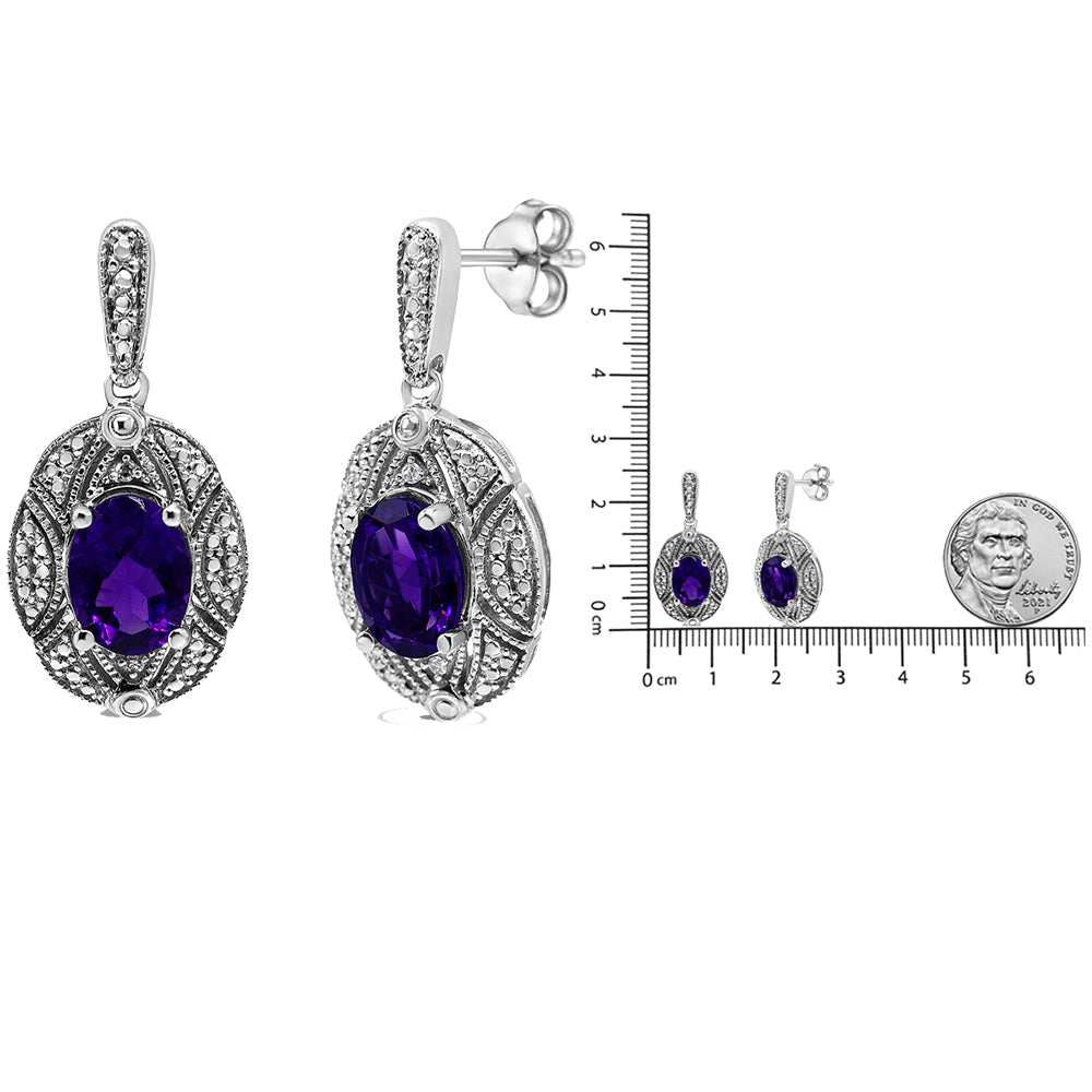 Pair of white metal earrings with oval purple gemstones and surrounding round white gemstones, shown from front and side angles, displayed next to a ruler and coin for size reference.