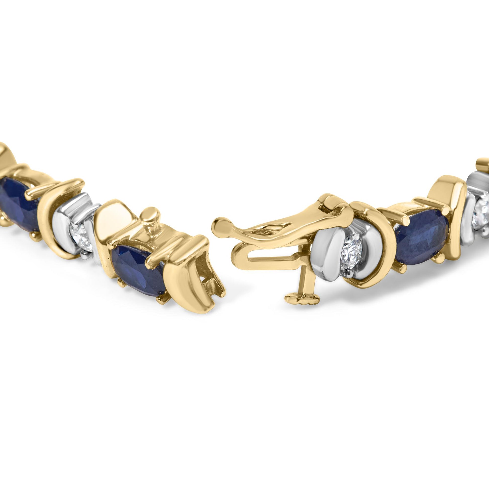 Close-up of a yellow metal bracelet with alternating oval blue gemstones in four-prong settings and round white gemstones in two-prong settings, shown partially open from a front angle.