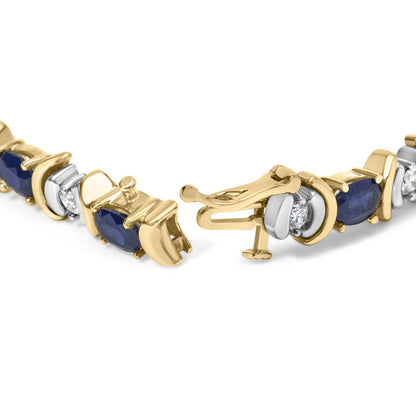 Close-up of a yellow metal bracelet with alternating oval blue gemstones in four-prong settings and round white gemstones in two-prong settings, shown partially open from a front angle.