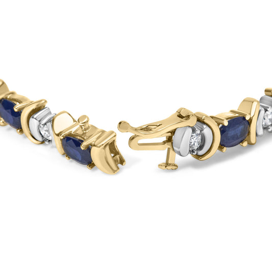 Close-up of a yellow metal bracelet with alternating oval blue gemstones in four-prong settings and round white gemstones in two-prong settings, shown partially open from a front angle.