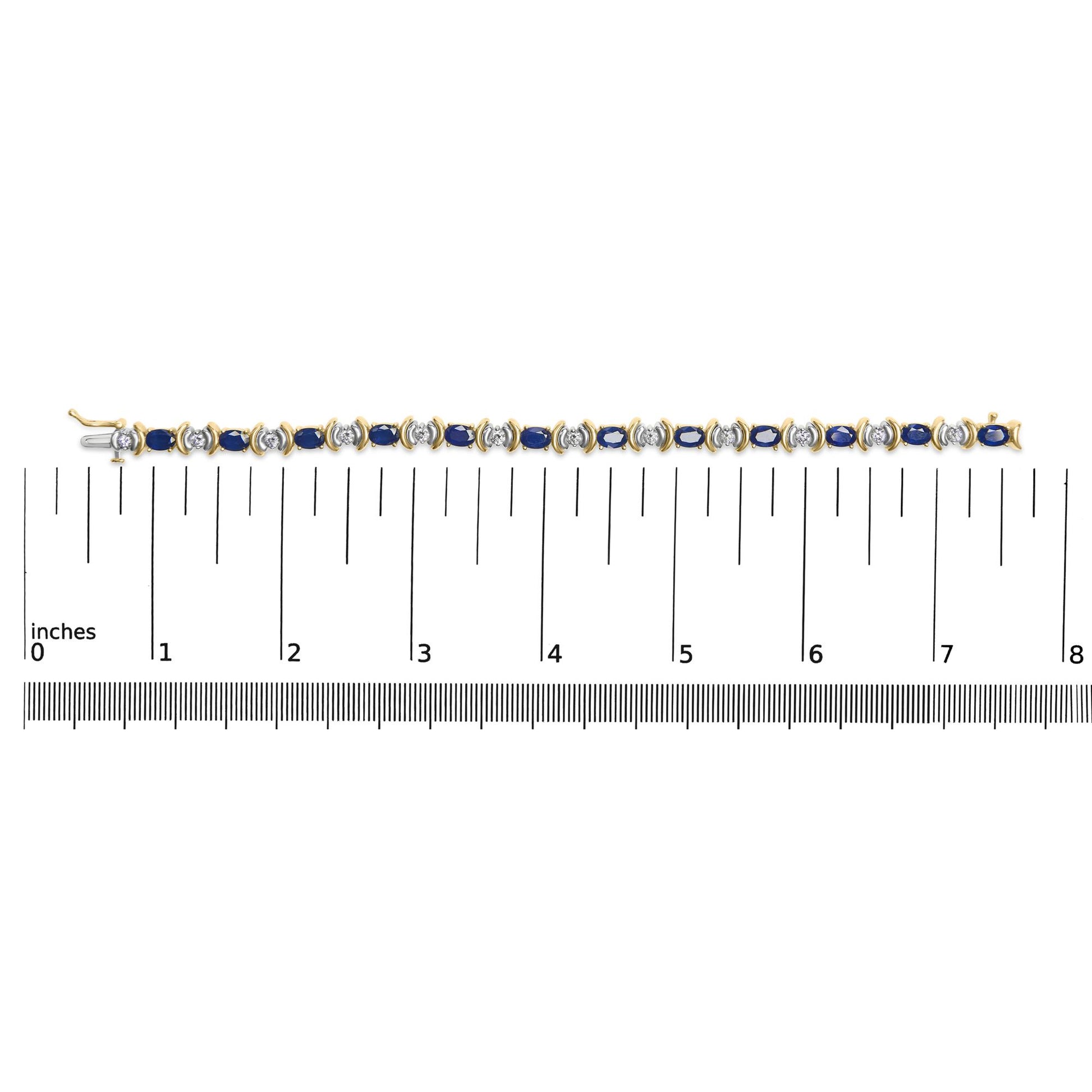 Top-down view of a yellow metal bracelet with alternating blue oval gemstones and white round gemstones, shown on a ruler for size reference.