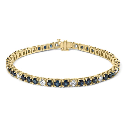 Yellow metal bracelet with alternating blue and white round gemstones in 4-prong settings, shown from a slightly angled top view.