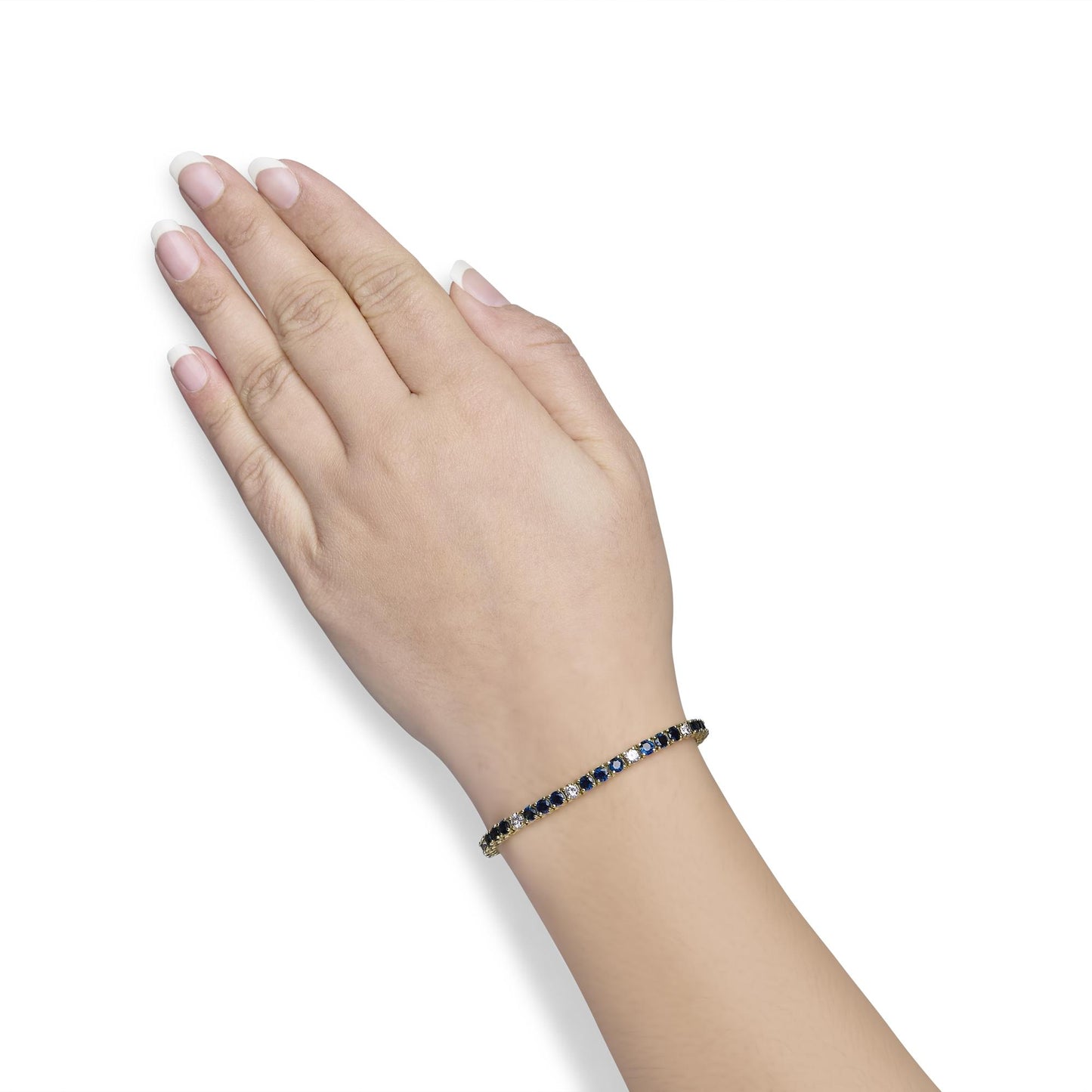 Yellow metal bracelet with alternating blue and white round gemstones in four-prong settings, worn on model's wrist, side angle view.