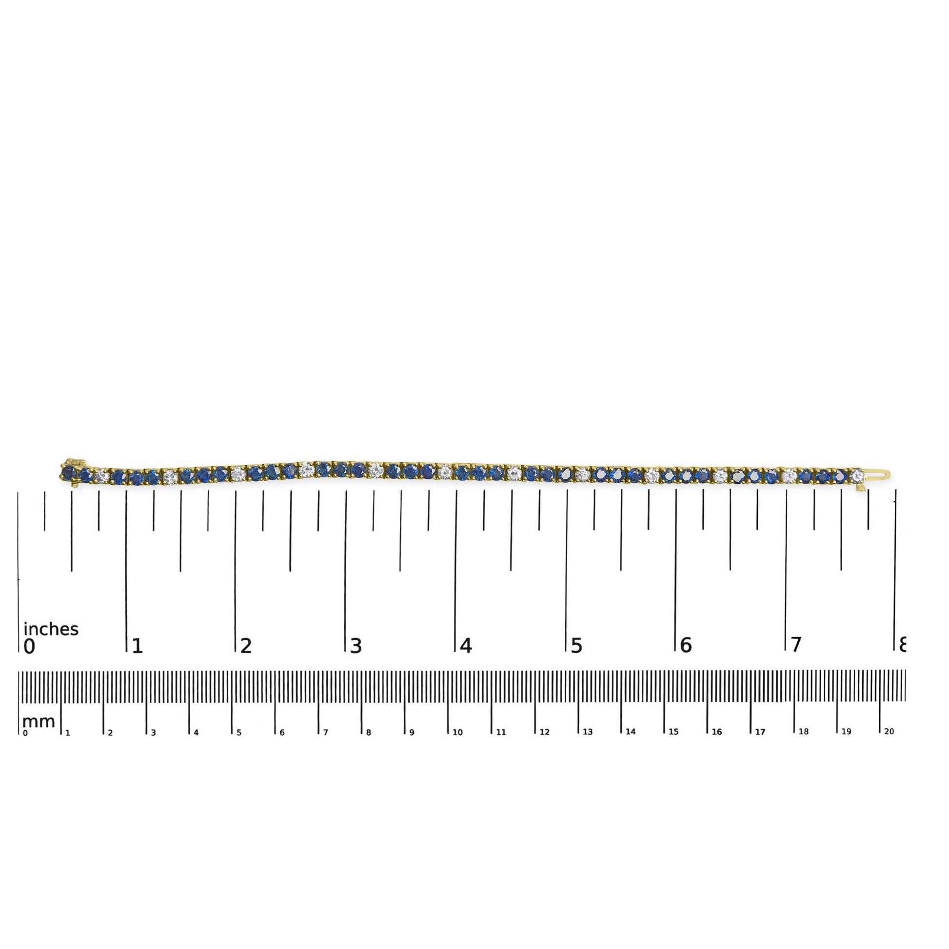 Yellow metal bracelet with alternating round blue and white gemstones in 4-prong settings, laid flat on a ruler for size reference, top-down view.
