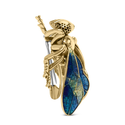 Side view of a yellow metal insect-shaped brooch with detailed blue wings and a silver pin fastening.