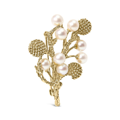 Yellow metal brooch designed as textured branches with round clusters and white round gemstones, shown from a front angle.