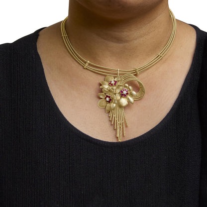 Yellow necklace with a floral pendant featuring red and white gemstones, shown worn on a model, front angle.