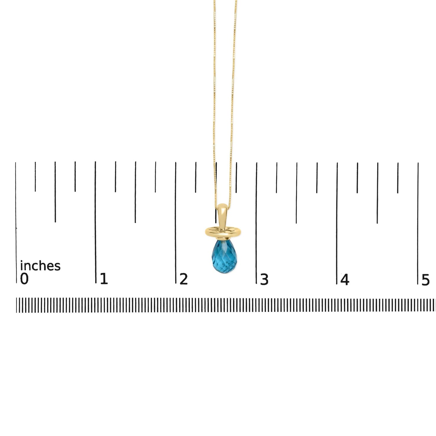 Yellow metal necklace with a blue faceted teardrop-shaped gemstone pendant, shown hanging against a ruler scale from a front angle.