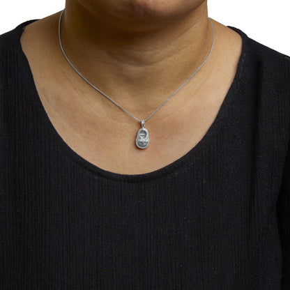 Close-up front view of a white metal necklace with a pendant featuring round white gemstones in a 4-prong setting, shown worn on a model.