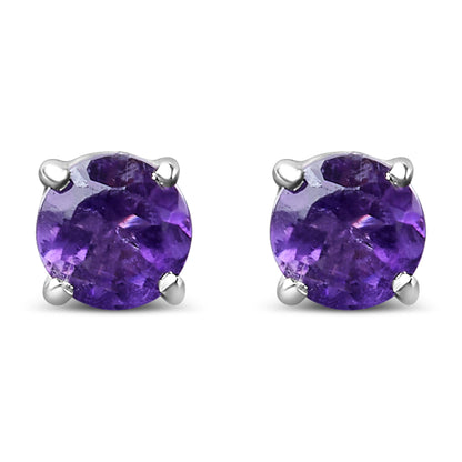 Close-up front view of a pair of white metal stud earrings with round purple gemstones held by four prongs.