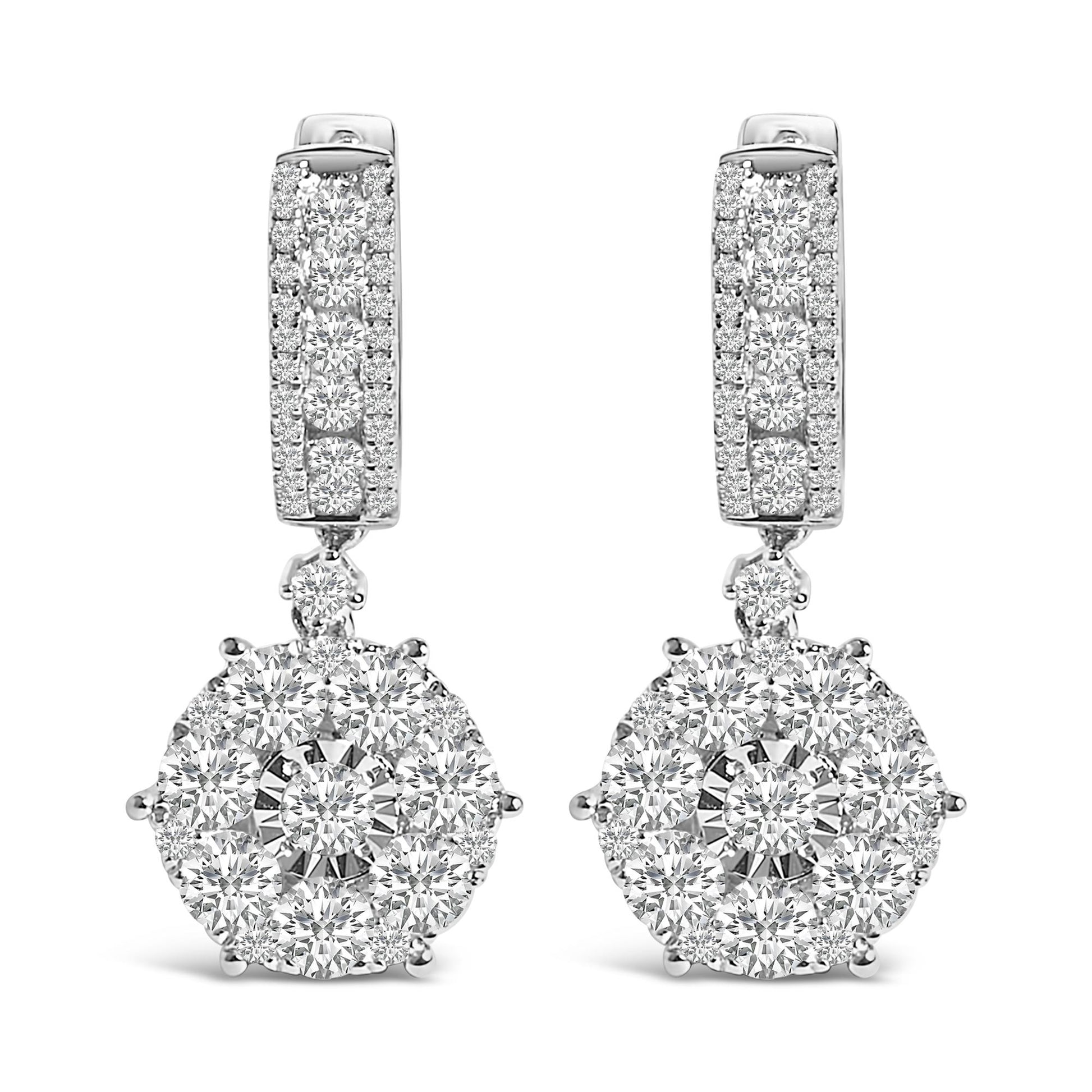 Front view of a pair of white metal drop earrings with multiple round white gemstones in various settings, featuring a rectangular upper part and a circular cluster pendant.