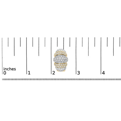 Close-up top view of a rounded earring with alternating yellow and white areas, pavé set with numerous small white gemstones, shown on a ruler for scale.