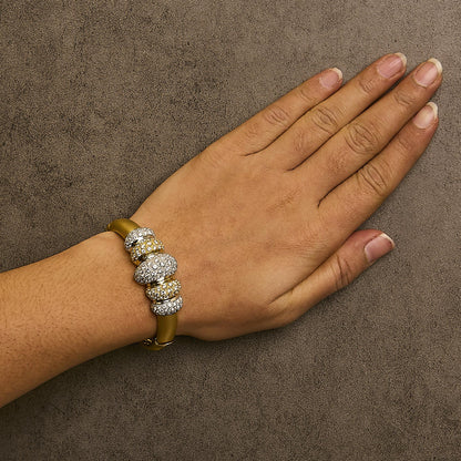 Bracelet with alternating yellow and white sections adorned with round white gemstones in a pave setting, shown worn on a model's wrist from top angle.
