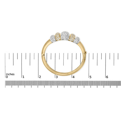Bracelet in yellow and white metal with five sections set with round white gemstones in pave setting, shown flat on a measuring scale from top view.