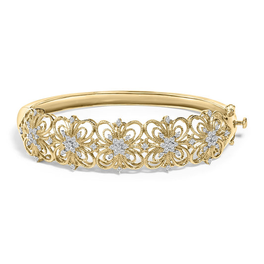 Yellow metal bracelet with intricate floral patterns set with multiple white round gemstones, shown from a side angle.