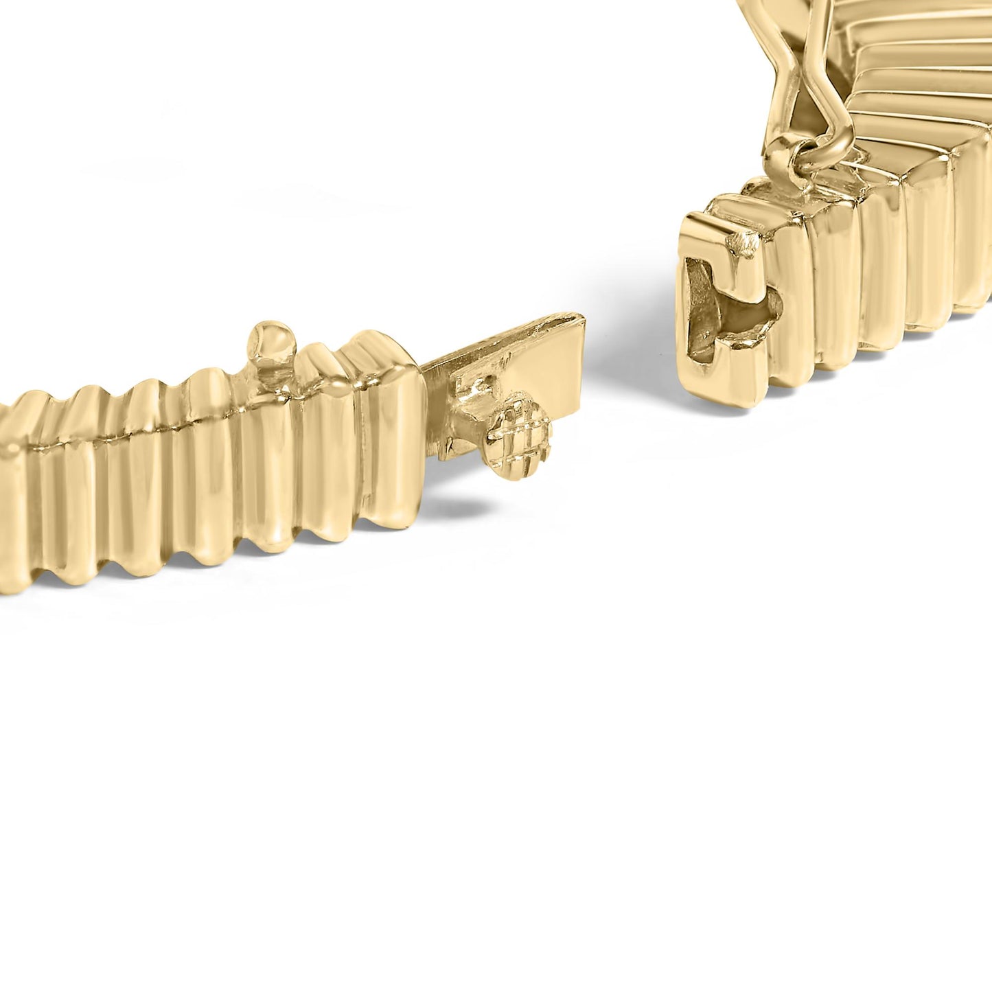 Close-up of an open yellow metal bracelet clasp with a ribbed design, shown from a slightly angled top view.