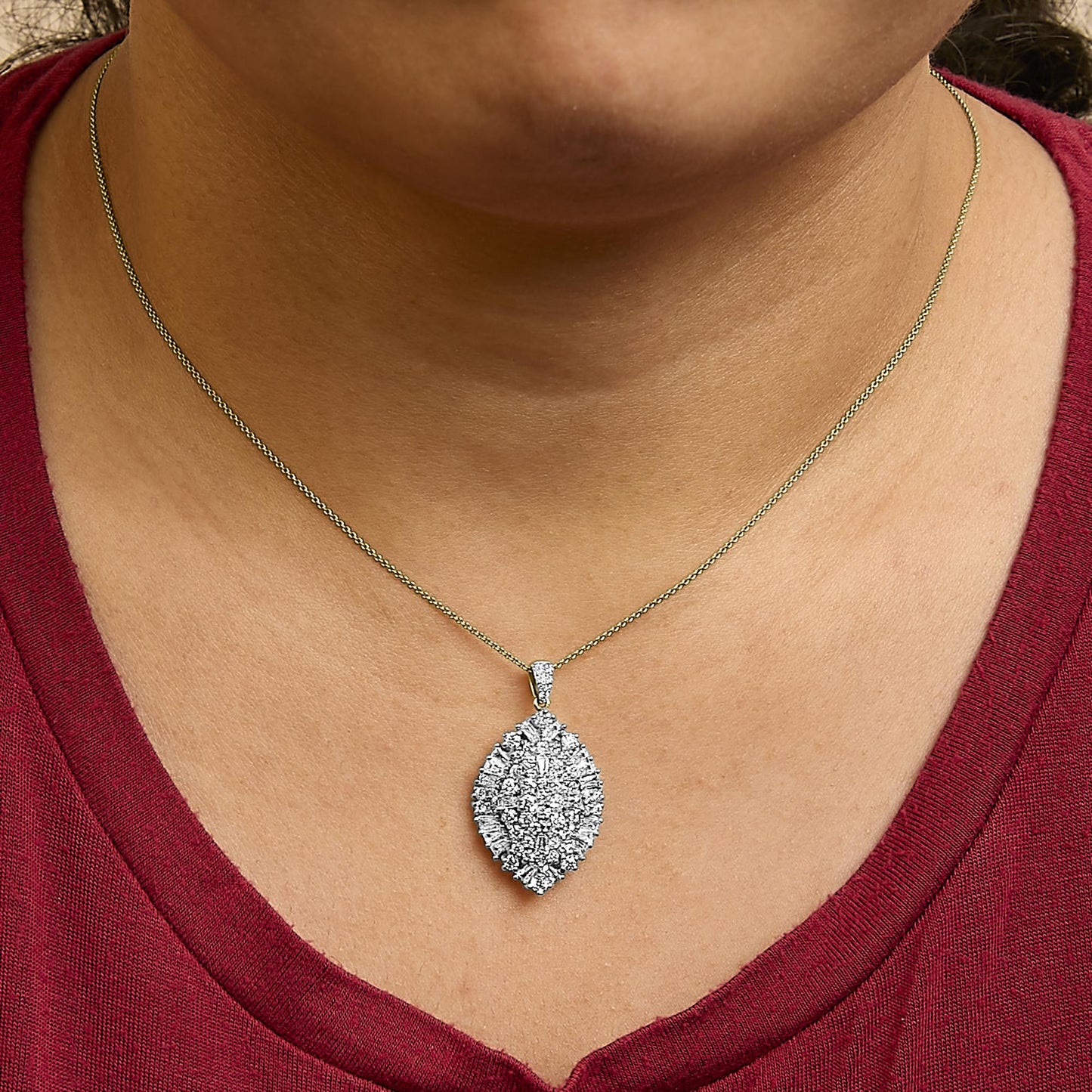 Necklace with marquise-shaped pendant featuring clustered white round and baguette gemstones in prong settings, shown worn on a model, front close-up angle.
