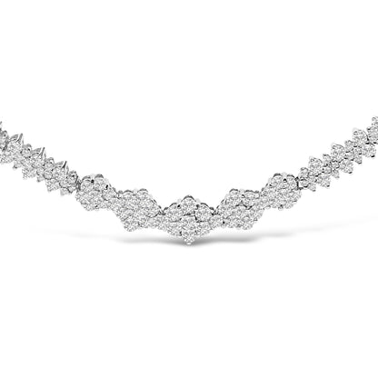 Close-up front view of a white metal necklace featuring multiple clusters of round white gemstones in shared prong settings, forming a symmetrical pattern.