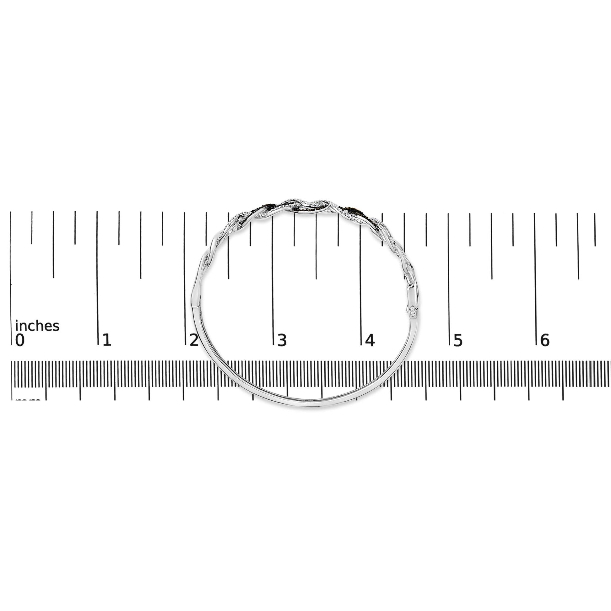 Bracelet with intertwined design featuring round black and white gemstones in shared prong settings, shown in top view on a scale.