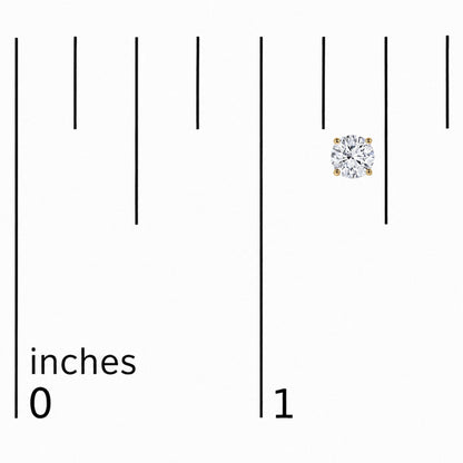 Close-up image of a single yellow metal stud earring with a round white gemstone in a four-prong setting placed on a scale, shot from above.
